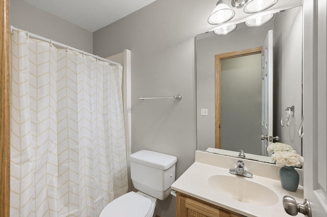 bathroom with vanity, toilet, and curtained shower