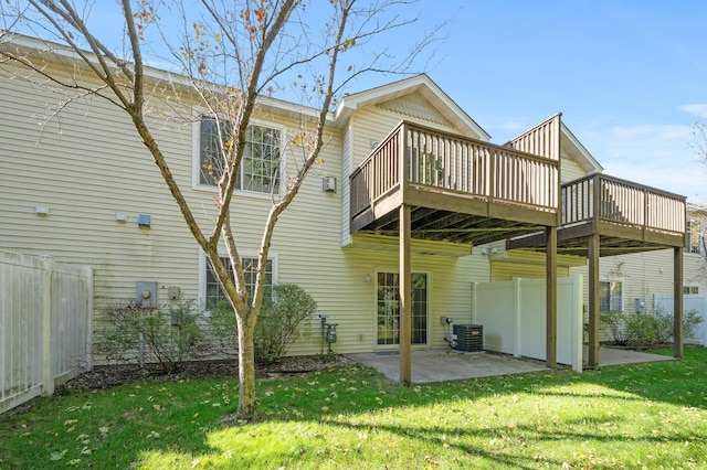 back of house with a wooden deck, a patio, central AC unit, and a yard