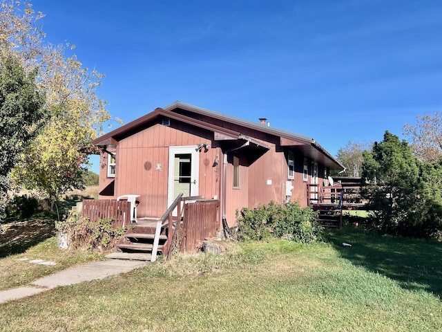 view of front facade featuring a wooden deck and a front yard