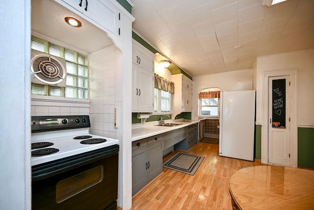 kitchen with white cabinets, sink, white appliances, gray cabinets, and light hardwood / wood-style floors