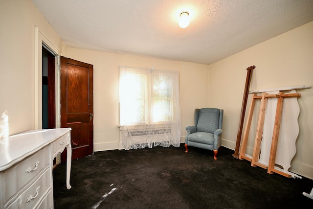 unfurnished room featuring dark carpet and a textured ceiling