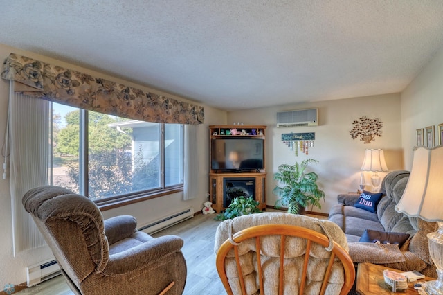 living room with a textured ceiling, baseboard heating, light wood-type flooring, and a wall mounted AC