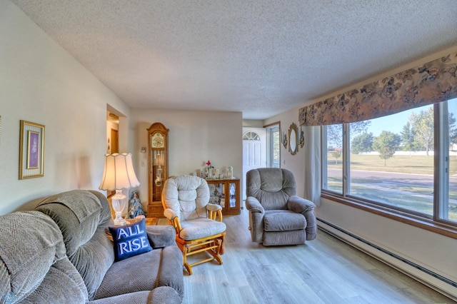 living room with a textured ceiling, baseboard heating, and hardwood / wood-style flooring