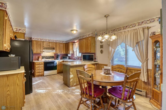 dining room featuring a notable chandelier, light wood-type flooring, wood walls, and a baseboard heating unit