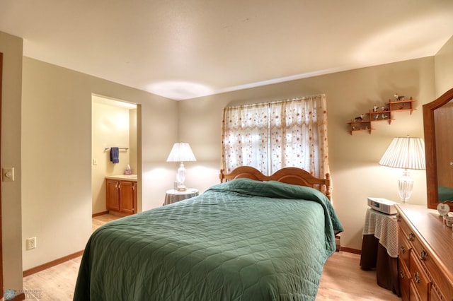 bedroom featuring light hardwood / wood-style flooring and connected bathroom