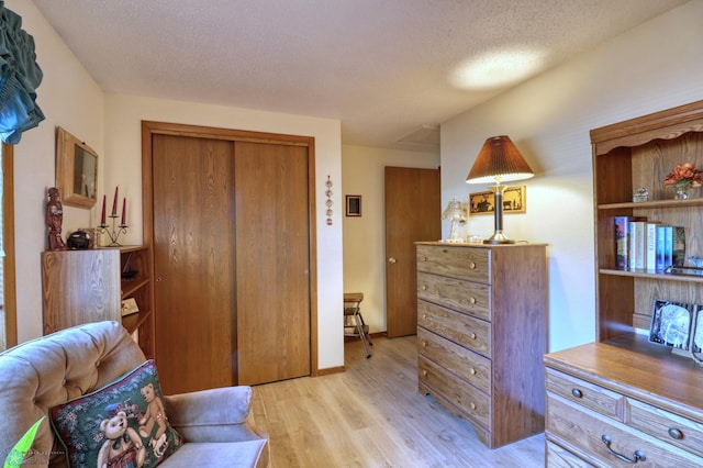 sitting room with a textured ceiling and light hardwood / wood-style flooring