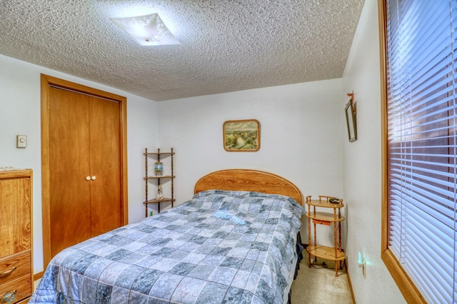 carpeted bedroom featuring a textured ceiling and a closet