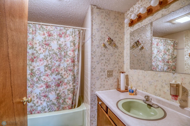 bathroom featuring a textured ceiling, vanity, and shower / bath combo with shower curtain