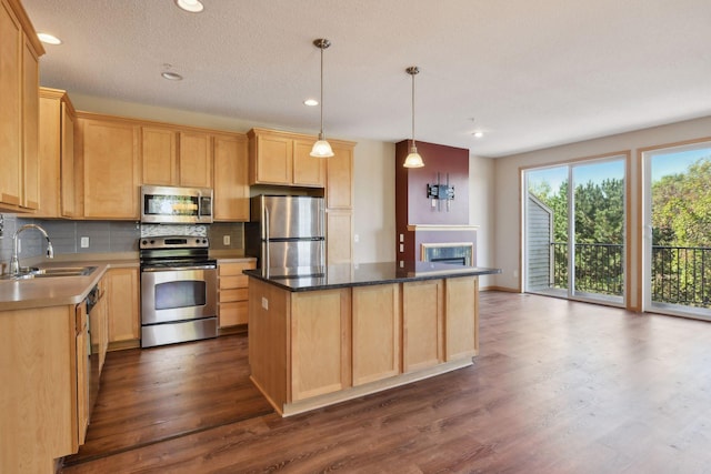 kitchen with light brown cabinets, sink, a kitchen island, stainless steel appliances, and dark hardwood / wood-style floors