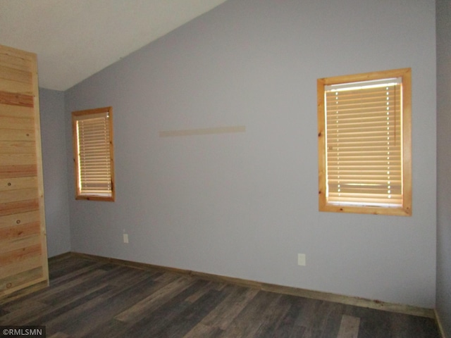 empty room with vaulted ceiling and dark hardwood / wood-style flooring