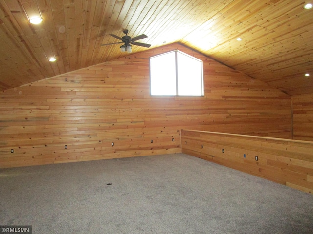 additional living space featuring vaulted ceiling, wooden ceiling, and wooden walls