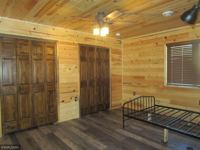 bedroom with wooden ceiling, wooden walls, and dark wood-style flooring