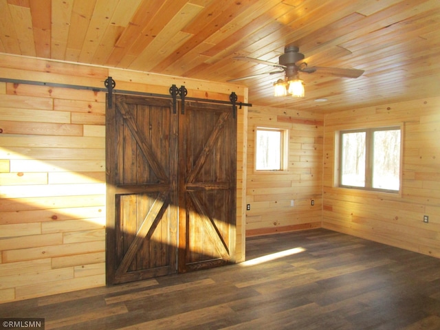 unfurnished room featuring wood finished floors, wood ceiling, wood walls, and a barn door