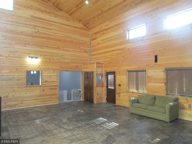 unfurnished living room with wooden ceiling, wood walls, and high vaulted ceiling