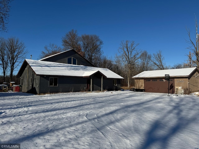 snow covered property featuring an outbuilding