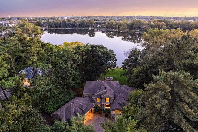 aerial view at dusk featuring a water view