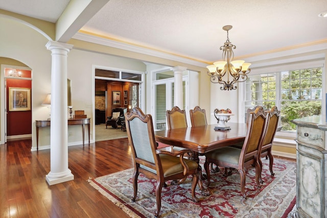 dining space featuring crown molding, a notable chandelier, a textured ceiling, built in shelves, and dark hardwood / wood-style flooring