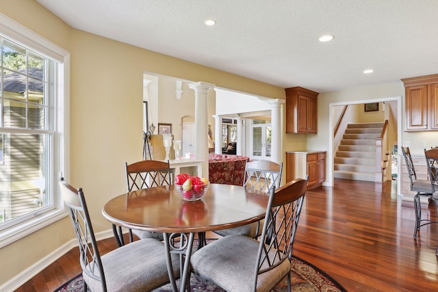 dining room with dark wood-type flooring, ornate columns, and a textured ceiling