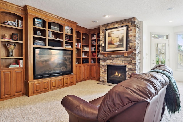 living room featuring carpet flooring, a textured ceiling, and a fireplace