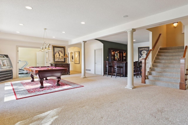 recreation room featuring pool table, a textured ceiling, bar area, and light colored carpet