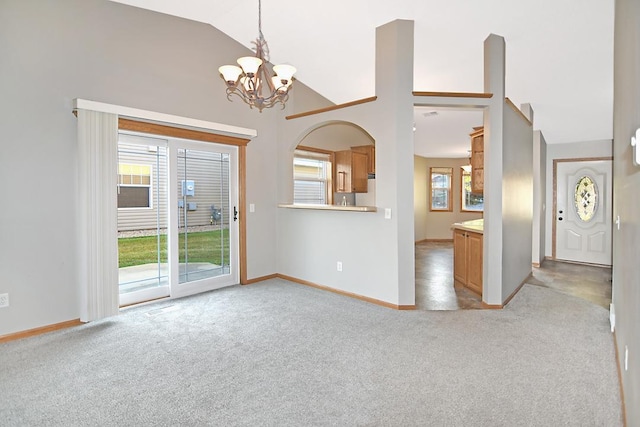 interior space with high vaulted ceiling, carpet, a notable chandelier, and baseboards