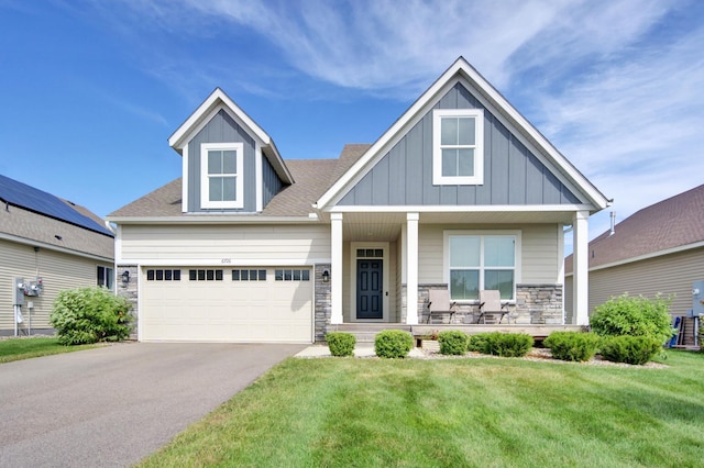 craftsman house with a garage, a front lawn, and covered porch