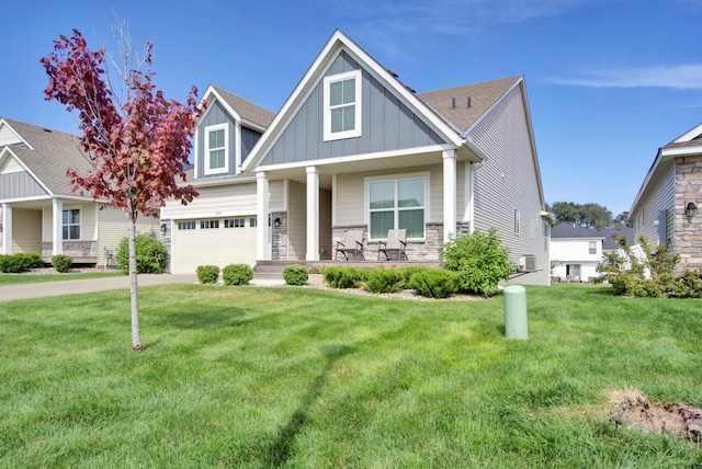 craftsman inspired home featuring a garage, a porch, and a front lawn