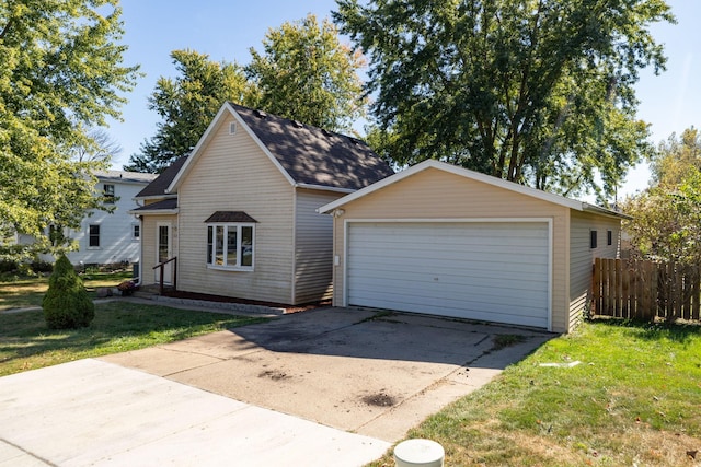 view of front of home featuring an outdoor structure, a front lawn, fence, and a detached garage