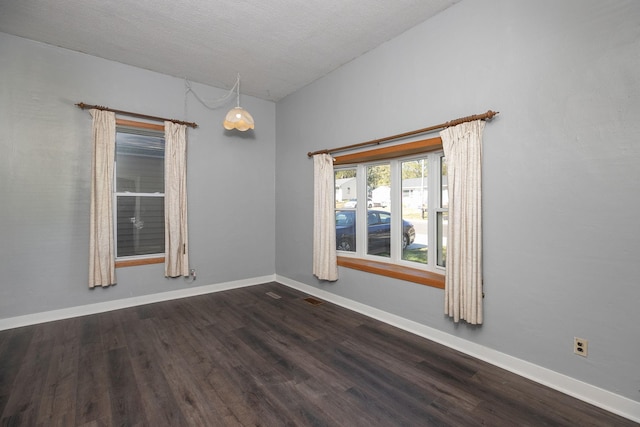empty room with baseboards, visible vents, wood finished floors, and lofted ceiling