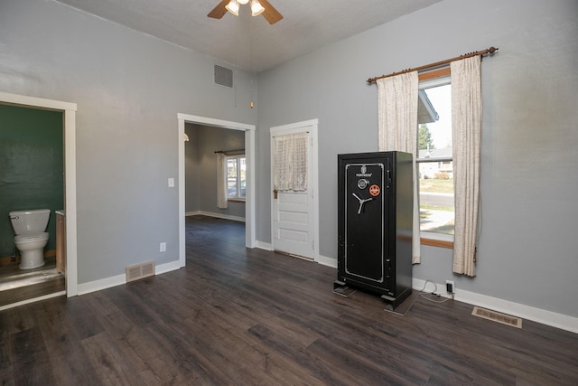 interior space with ceiling fan, wood finished floors, and visible vents