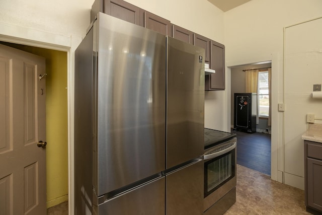 kitchen with light countertops, dark brown cabinets, and stainless steel appliances