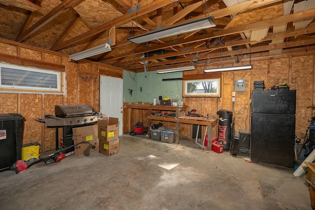 garage with freestanding refrigerator and a workshop area
