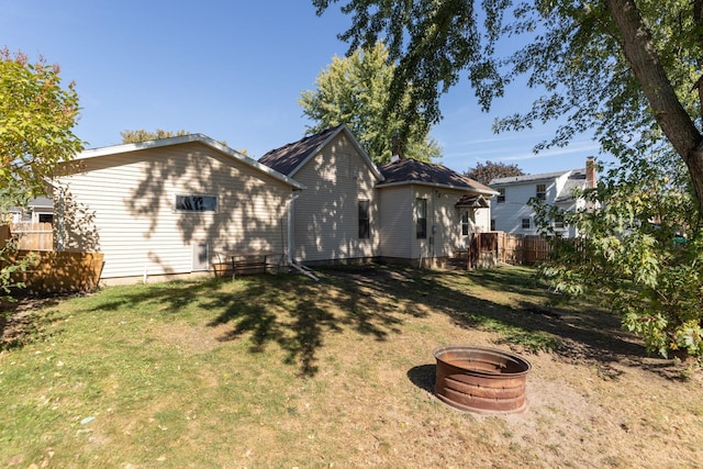 back of property featuring fence and a yard