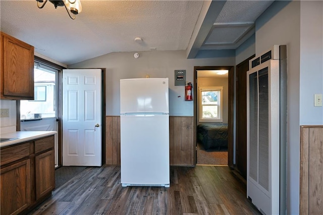 kitchen with freestanding refrigerator, dark wood-style flooring, a heating unit, and wainscoting