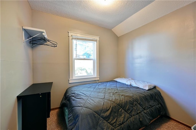 bedroom with carpet floors, baseboards, a textured ceiling, and lofted ceiling