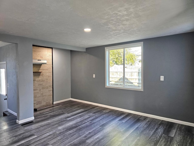 basement with a textured ceiling and dark hardwood / wood-style flooring