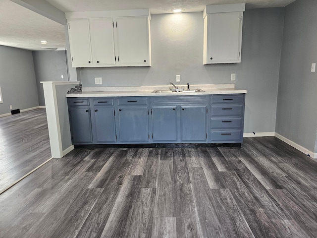 kitchen featuring a textured ceiling, white cabinets, sink, and dark hardwood / wood-style flooring