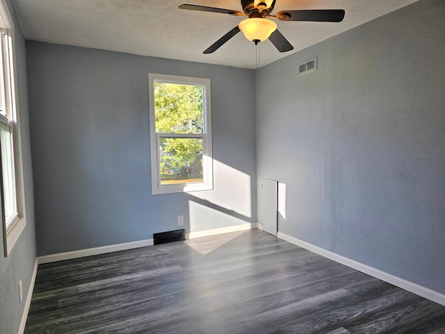 empty room featuring dark wood-type flooring and ceiling fan