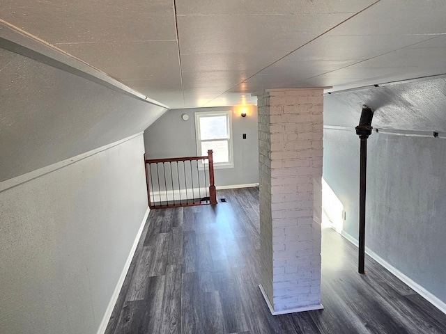 bonus room featuring lofted ceiling, ornate columns, and dark hardwood / wood-style flooring