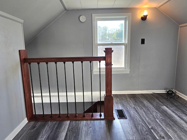 additional living space featuring dark wood-type flooring and vaulted ceiling