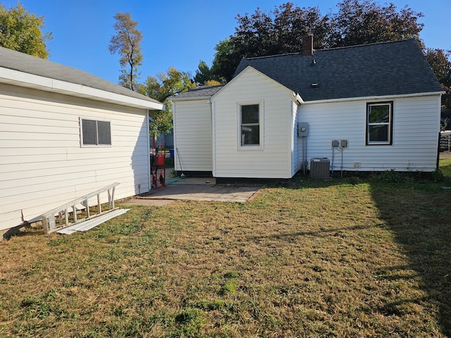 rear view of property featuring central AC, a yard, and a patio area