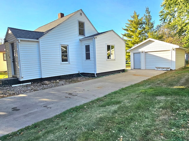 view of side of property with a yard, an outdoor structure, and a garage