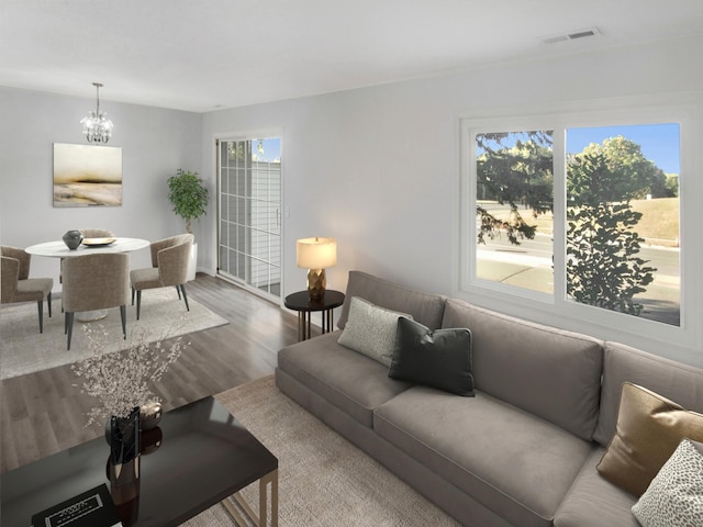 living room featuring an inviting chandelier, hardwood / wood-style floors, and plenty of natural light