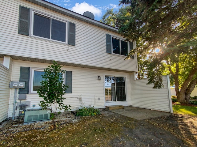 rear view of property featuring a patio and central AC