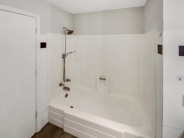 bathroom featuring wood-type flooring and  shower combination