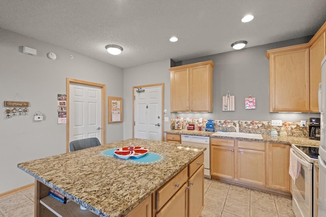 kitchen featuring white appliances, a kitchen island, light stone countertops, a textured ceiling, and sink