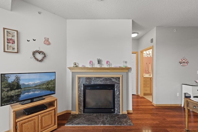 living room with a textured ceiling, a fireplace, and dark hardwood / wood-style flooring