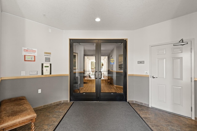 interior space with french doors and a textured ceiling