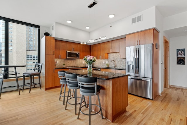 740 Portland Ave Unit 1207, Minneapolis, MN 55415 - kitchen with light wood-style floors, appliances with stainless steel finishes, visible vents, and a sink