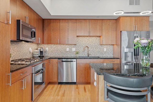 740 Portland Ave Unit 1207, Minneapolis, MN 55415 - kitchen with a sink, dark stone counters, stainless steel appliances, visible vents, and decorative backsplash